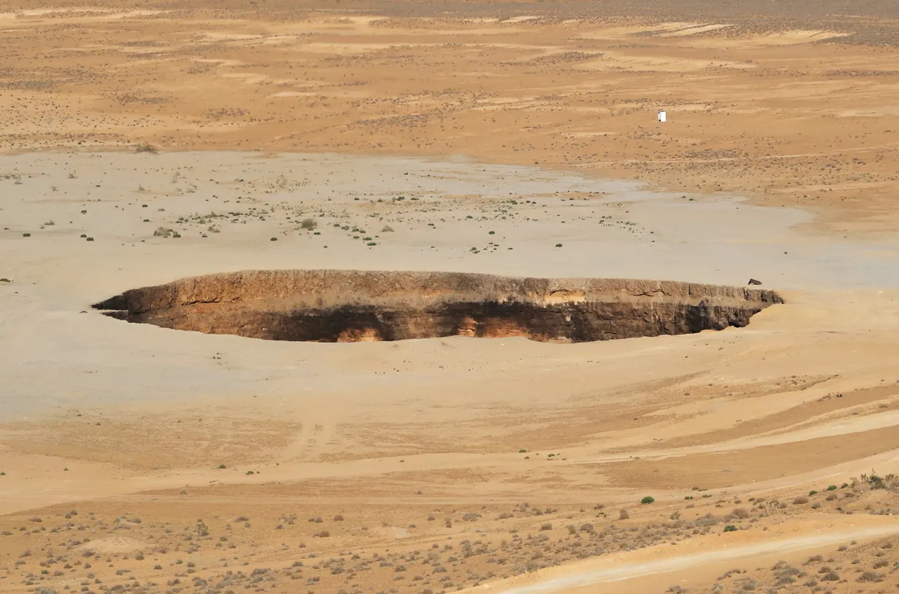 A dark crater bowl surrounded by pale desert