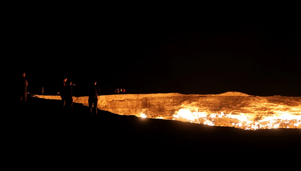 Flames visible across the crater from a distant rim