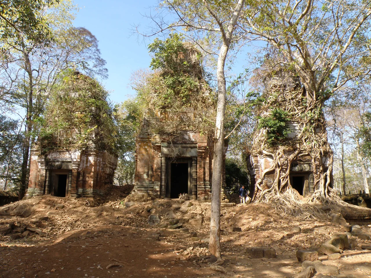 Brick temple towers at Prasat Pram, with tree roots around one tower