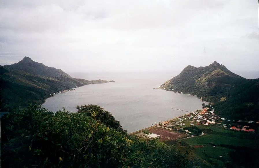 Ahurei village and bay beneath green slopes on Rapa Iti