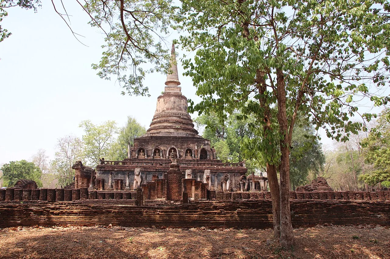 Wat Chang Lom chedi and elephant figures framed by trees at Si Satchanalai, April 2019