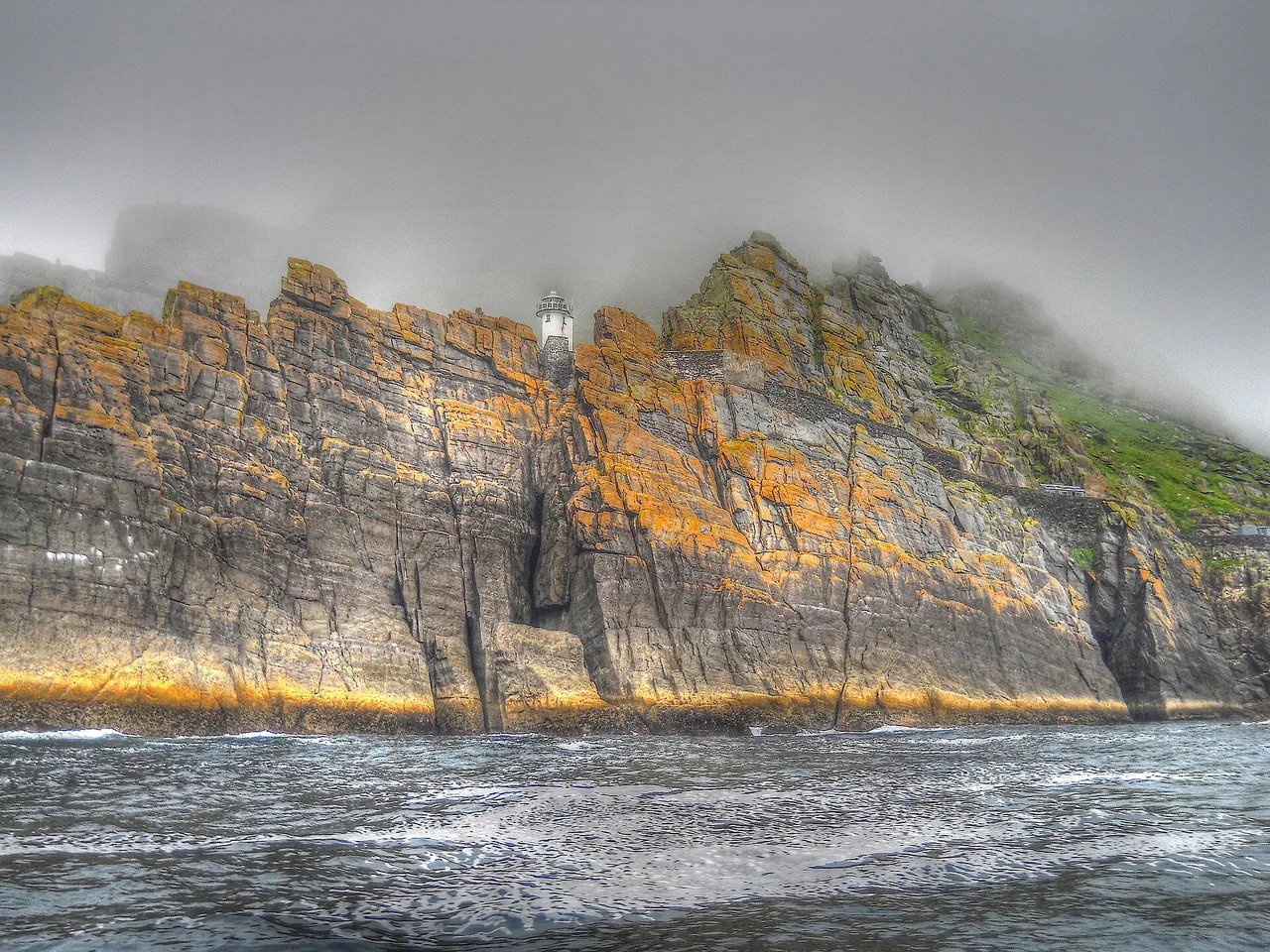 Skellig Michael's rocky coast and lighthouse above the sea in September 2012