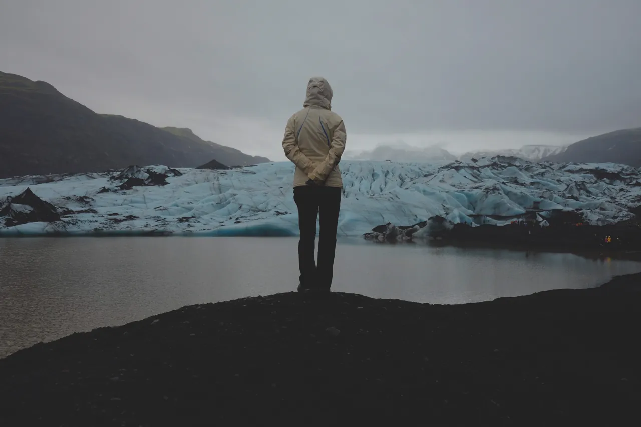 A visitor looking towards Sólheimajökull’s ice and lagoon